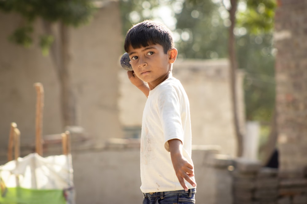 a young boy holding a cell phone to his ear