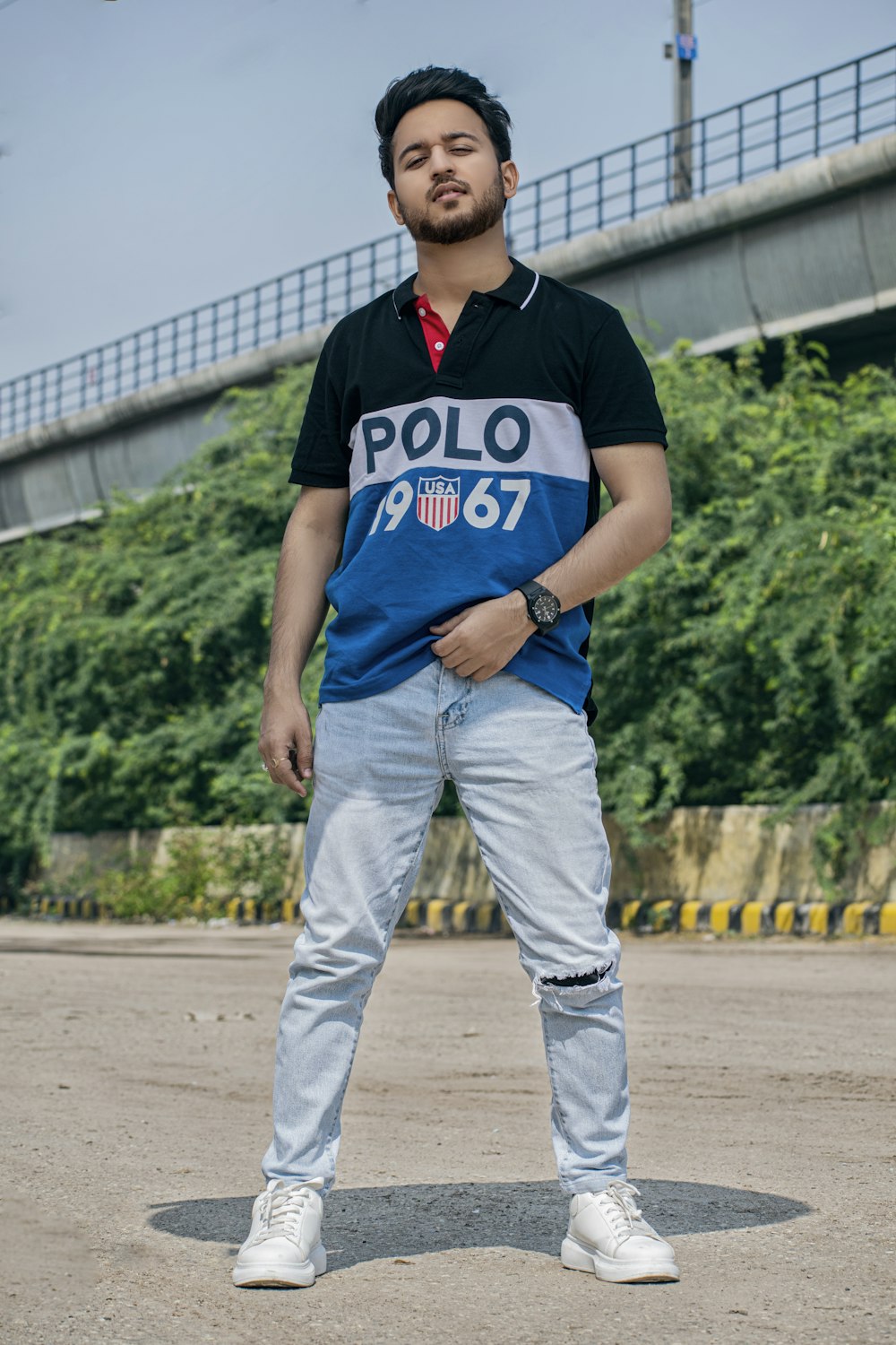 a man in a polo shirt standing in a parking lot