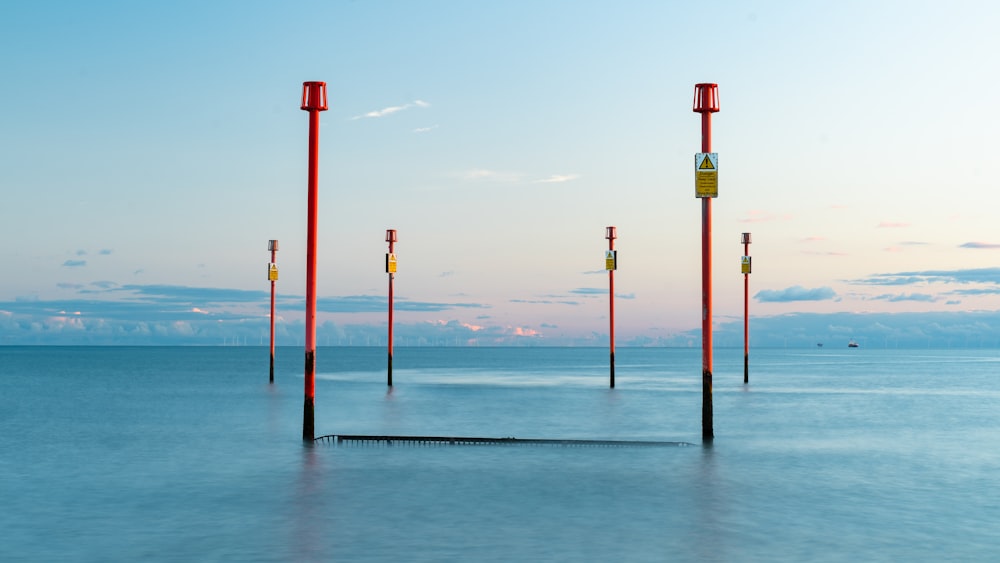 a row of poles sitting in the middle of a body of water