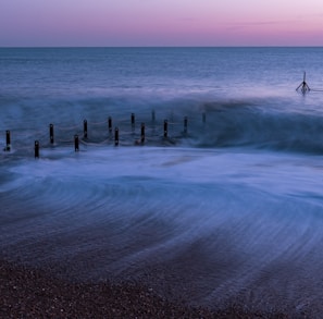 a person standing on a beach next to the ocean