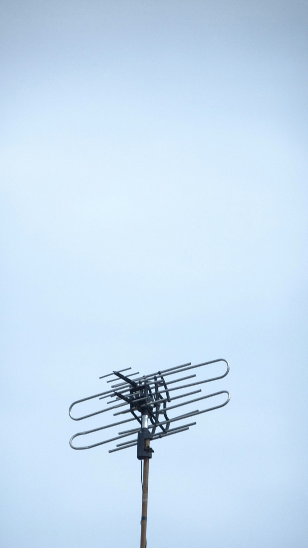 a television antenna on top of a wooden pole