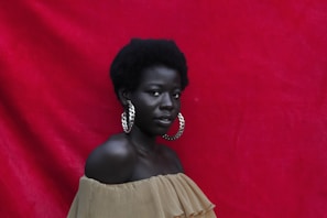 Community manager en un fondo rojo con traje marron
