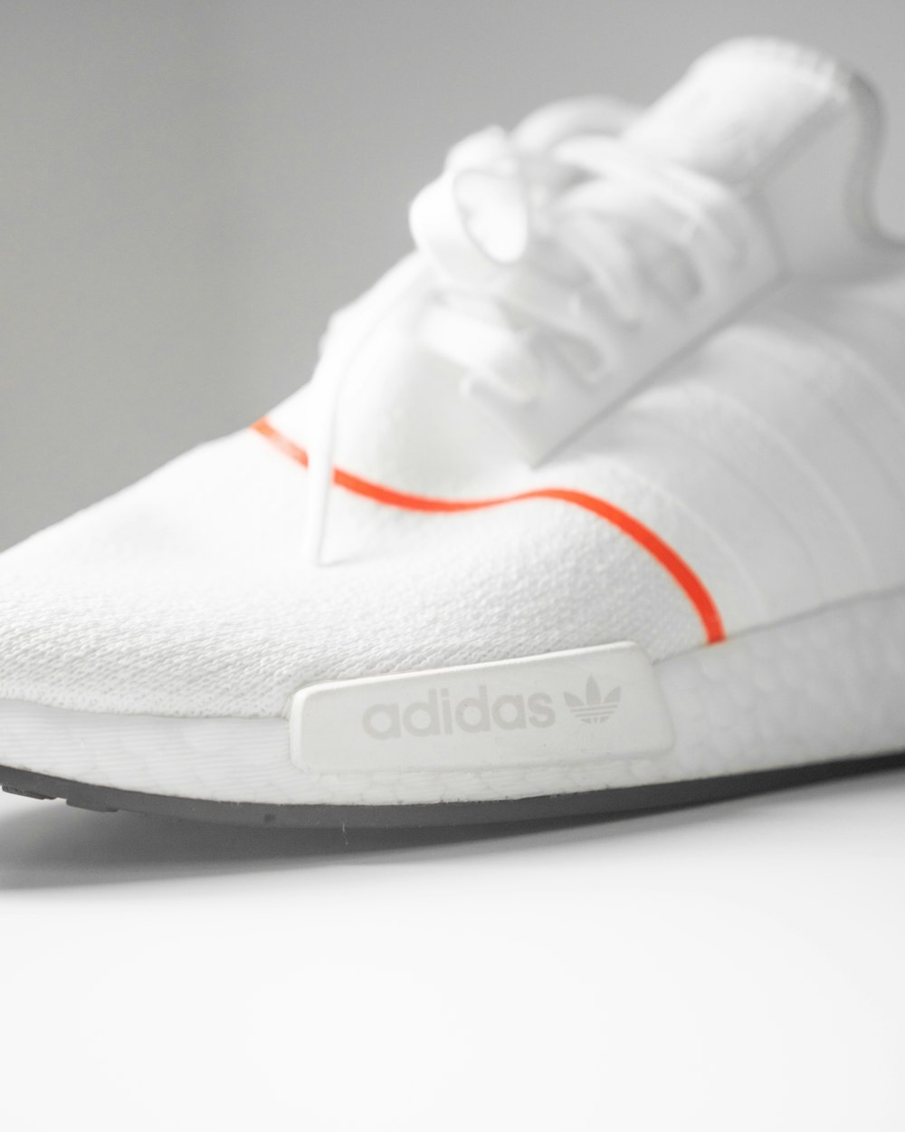 a white adidas sneakers with an orange stripe