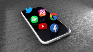Social media icons floating above a smartphone screen.