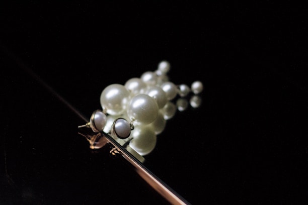 A collection of various pearl jewelry pieces displayed on a wooden surface.