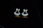 Pair of diamond earrings glowing softly under warm light