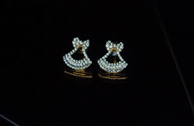 A pair of sparkling diamond earrings displayed against a black velvet background
