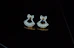 Elegant gold earrings displayed on a soft velvet cushion.
