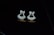 Two gold earrings adorned with sparkling diamonds are placed on a glossy black surface, creating a luxurious and elegant appearance.