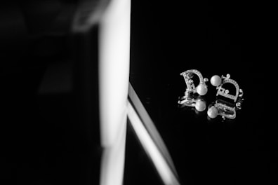 Elegant drop earrings catching the light against a minimalist white background.