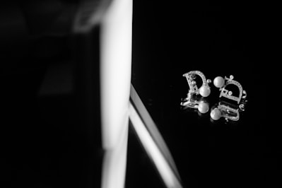 Close-up of elegant pearl earrings resting on a soft fabric background
