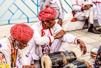a group of men sitting on the ground next to each other
