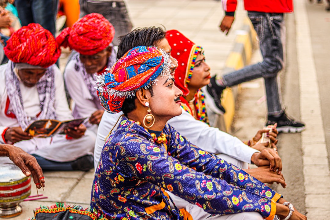 a group of people sitting on the side of a road,