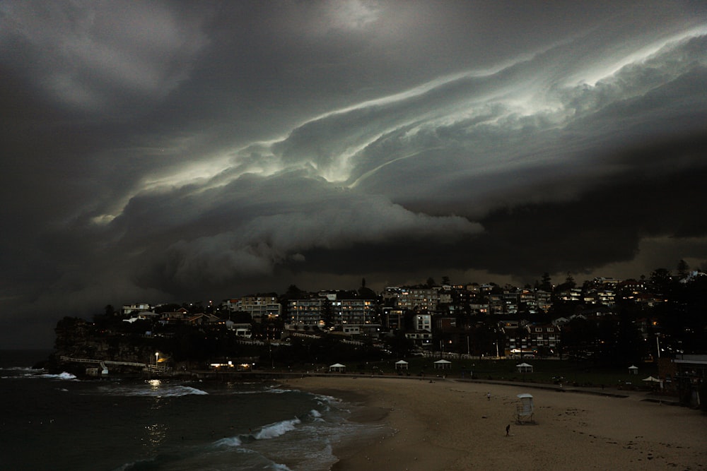 a storm is coming over a city on a beach