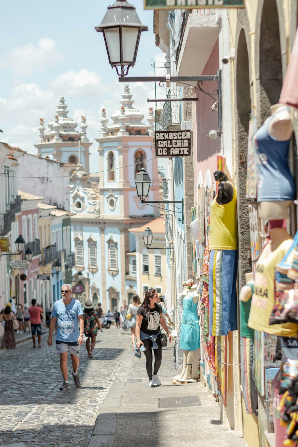 a group of people walking down a street next to buildings