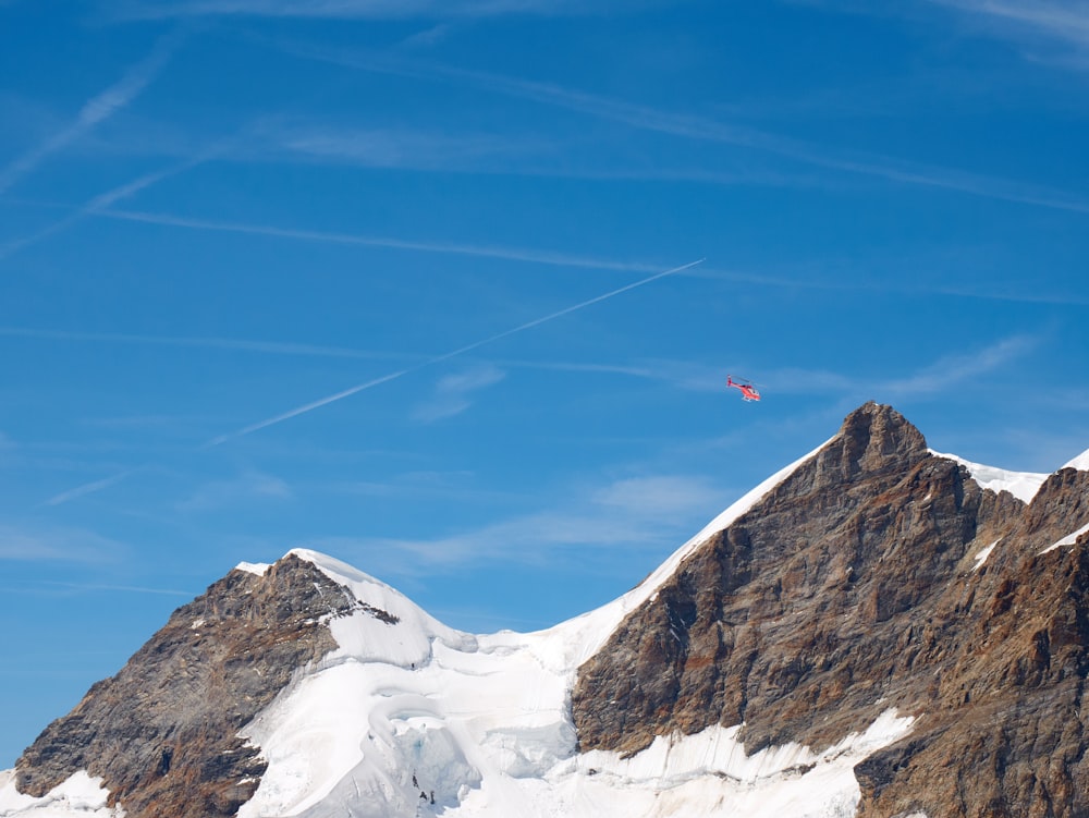 a plane flying over a snow covered mountain