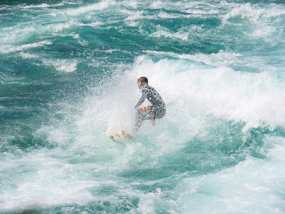 a man riding a wave on top of a surfboard