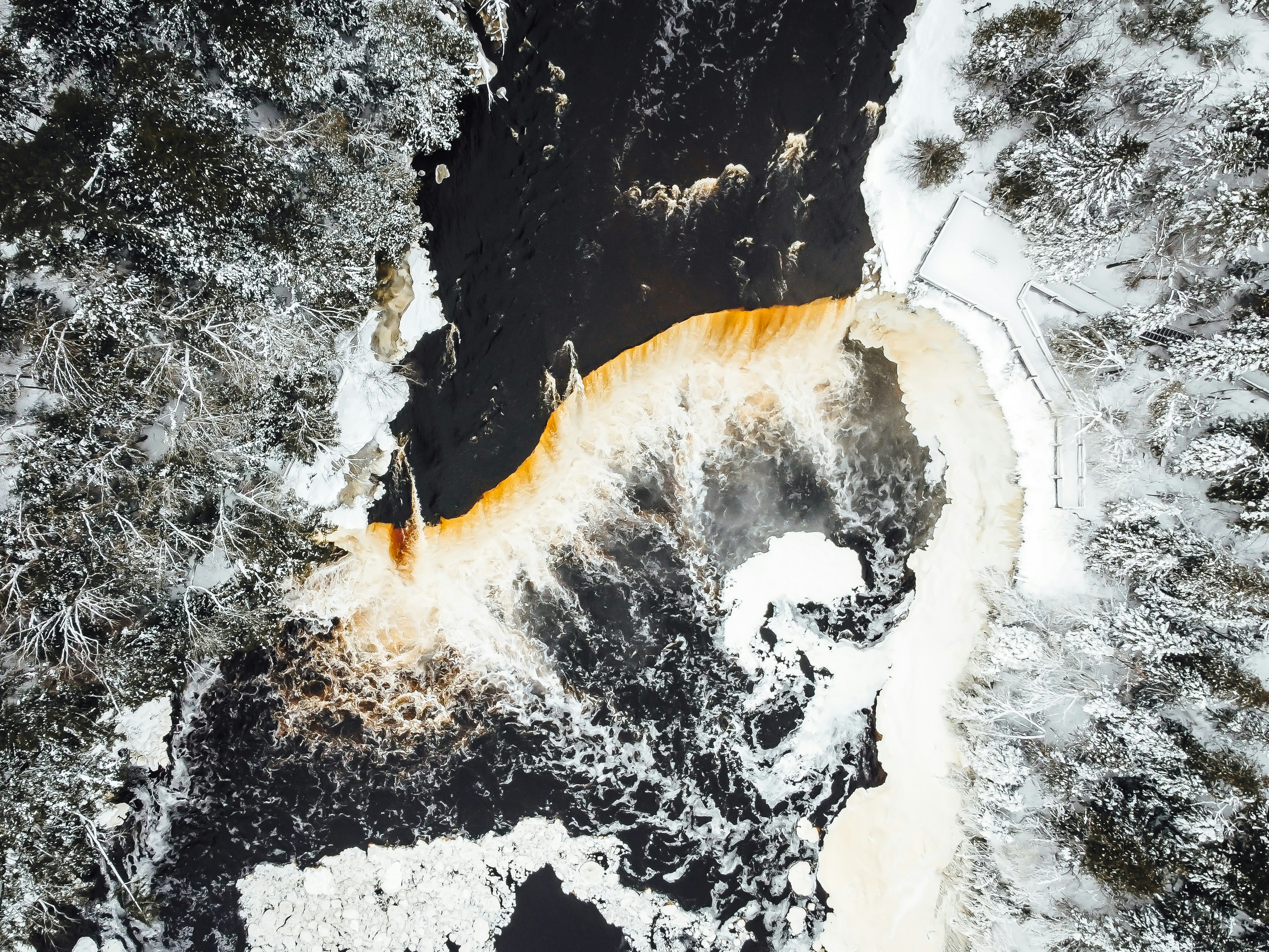 an aerial view of a river in the snow