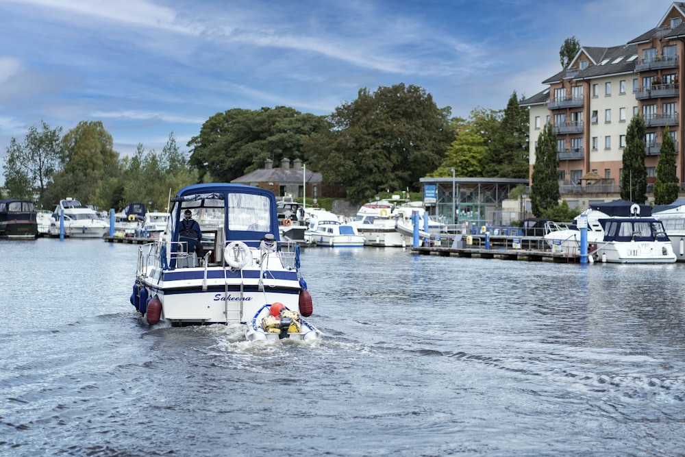 a blue and white boat traveling down a river