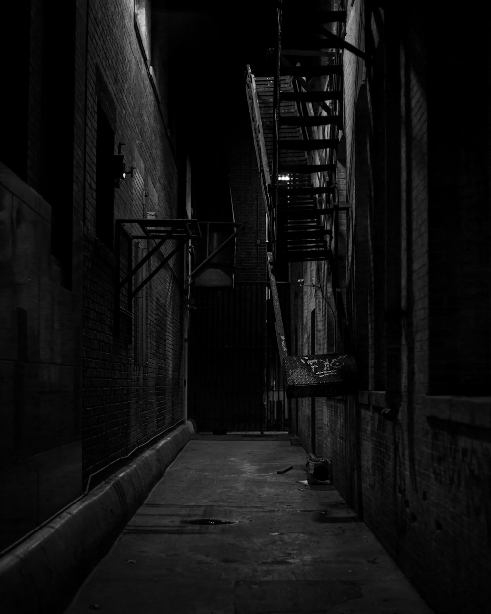 a dark alley way with a fire escape