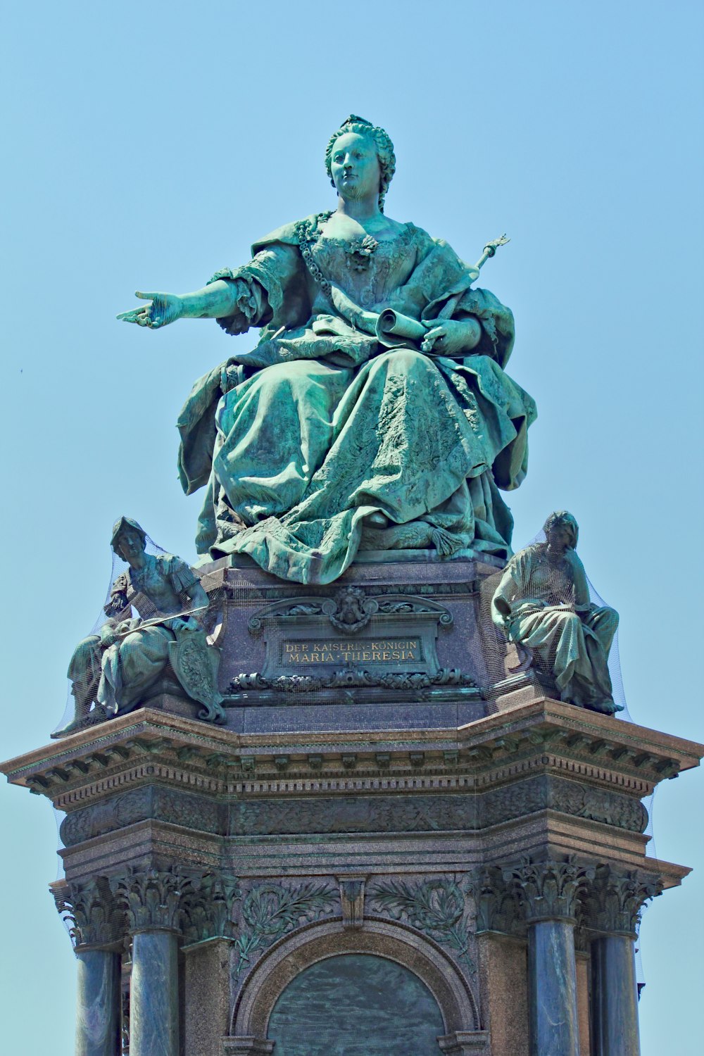 a statue of a woman sitting on top of a clock tower