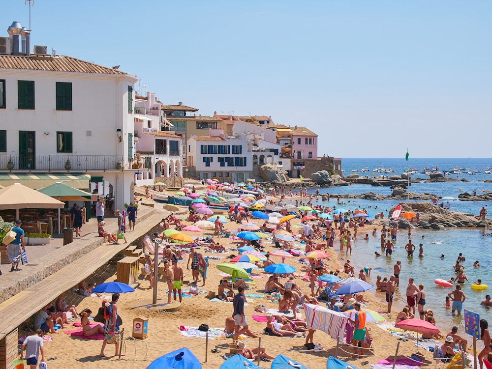 a crowded beach with lots of people and umbrellas