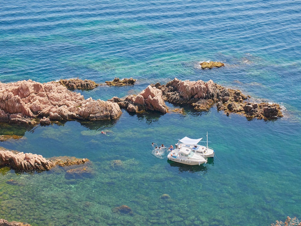 a small boat in the water near some rocks