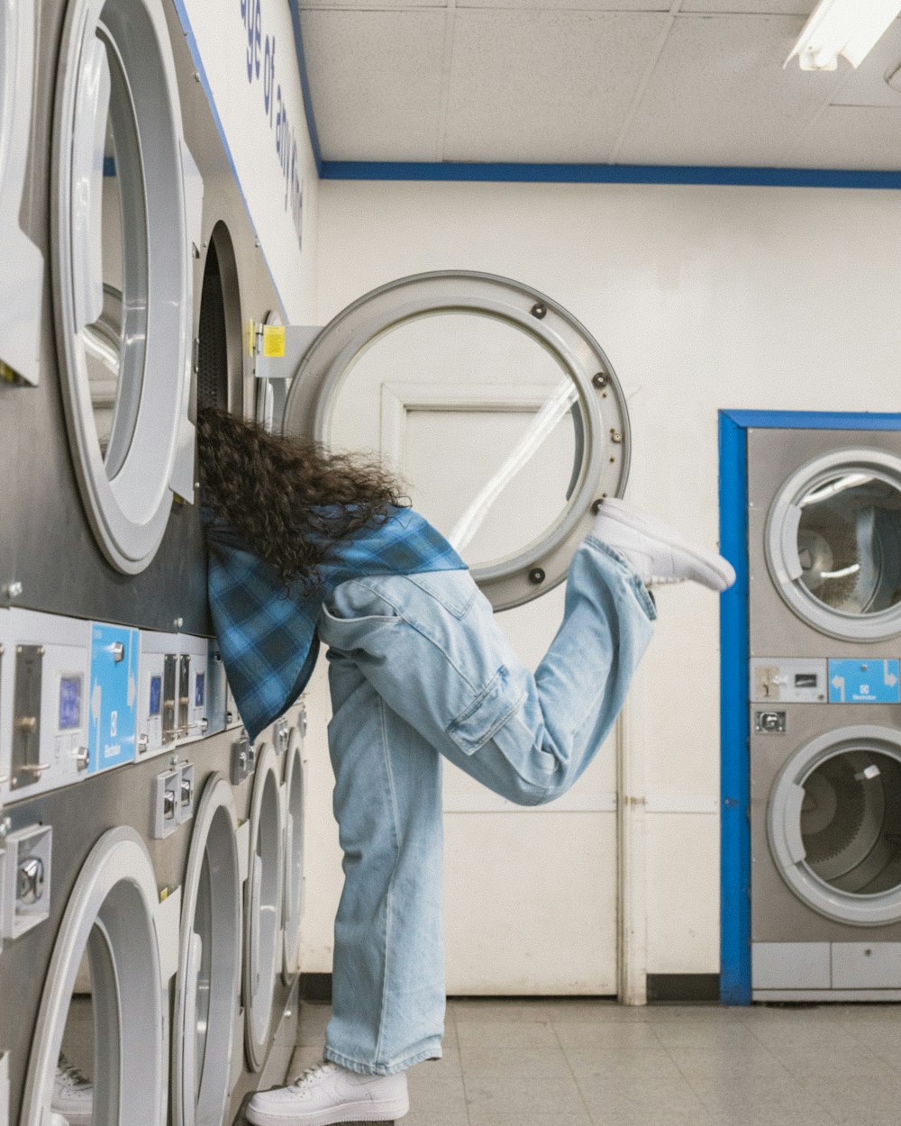 a woman leaning on a stack of washing machines