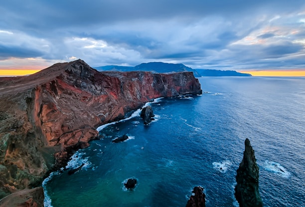 a large body of water next to a rocky cliff