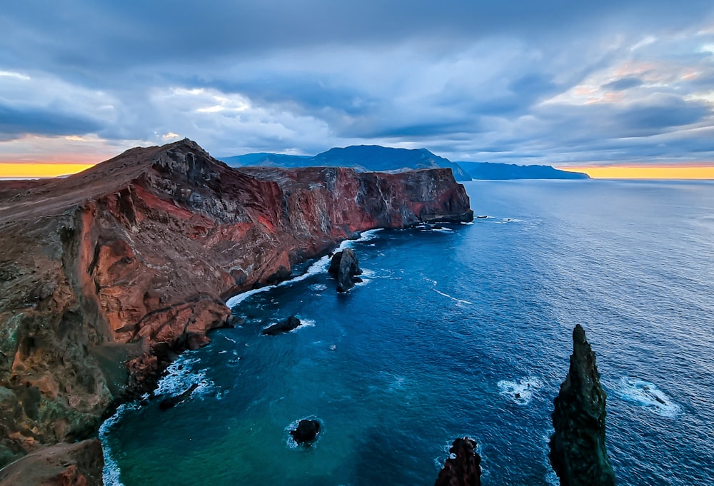 a large body of water next to a rocky cliff