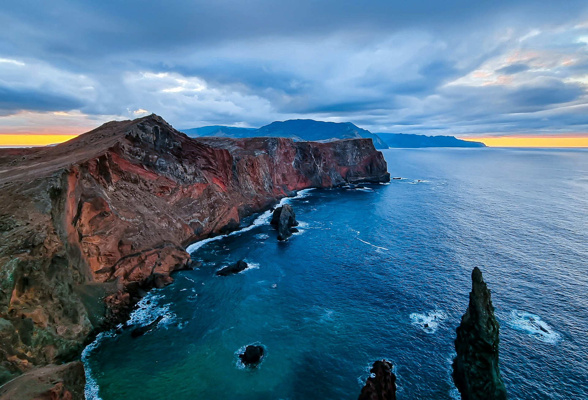 a large body of water next to a rocky cliff