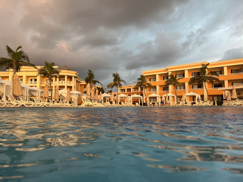 a resort with a pool and palm trees in the background