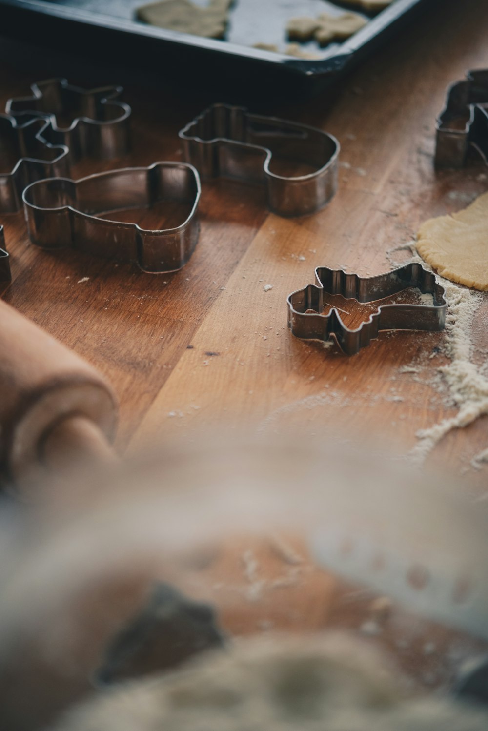 a wooden table topped with cookie cutters and dough