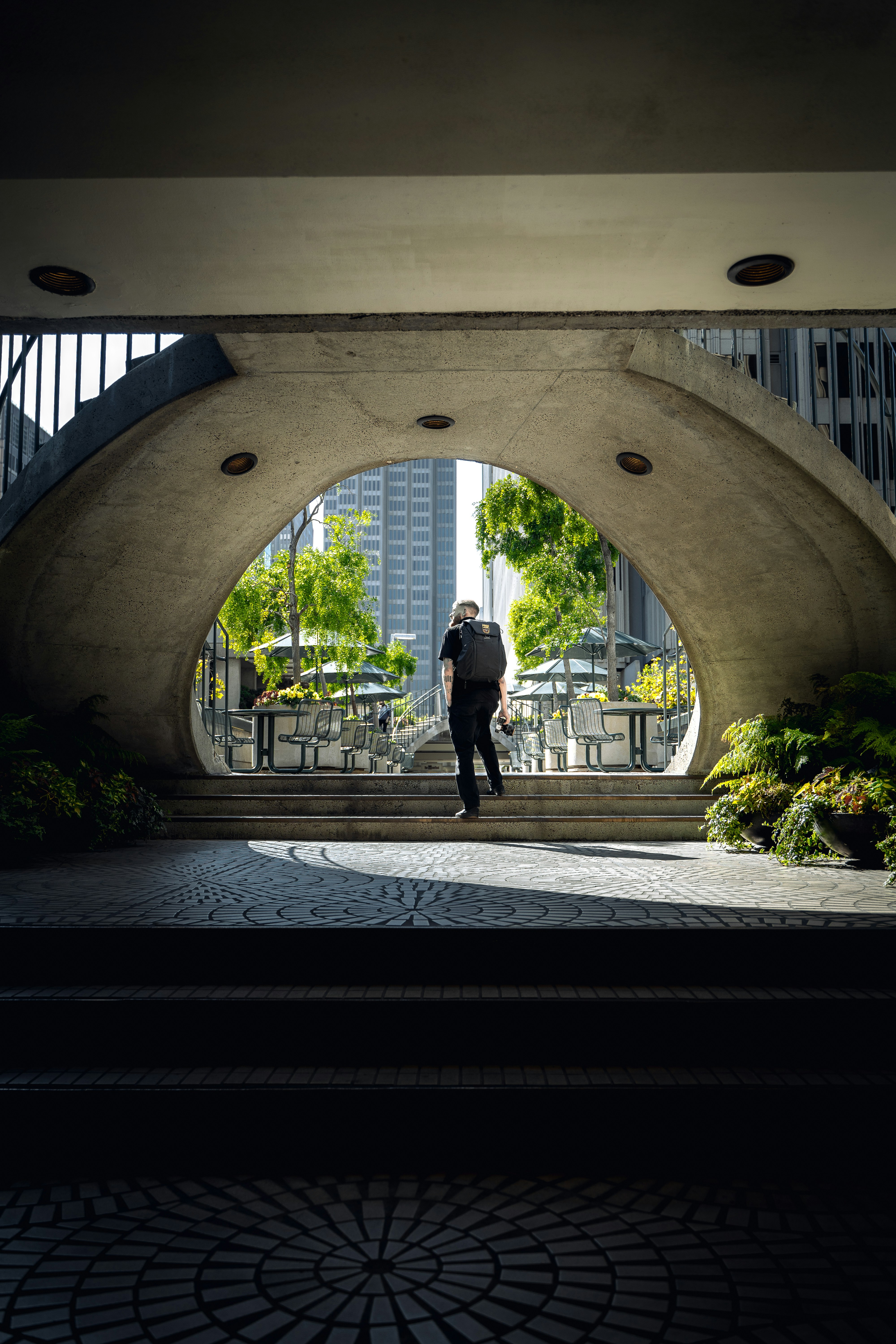 a man is walking through a tunnel in a city