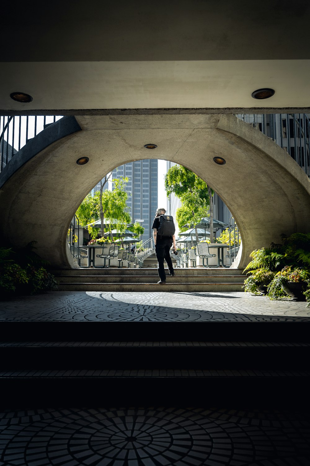 a man is walking through a tunnel in a city