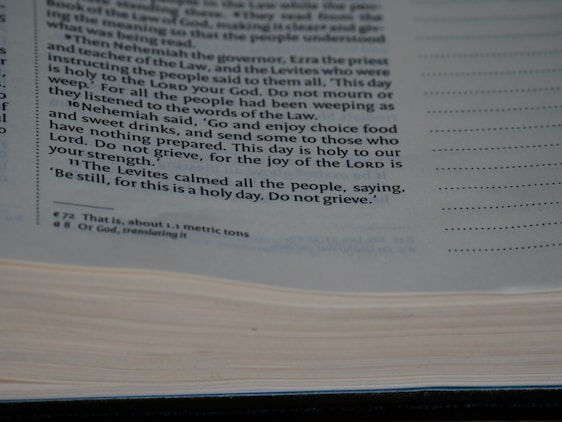 A close-up view of a page from a book containing printed text. The text discusses a religious or historical narrative, mentioning Nehemiah, the Levites, and the importance of a holy day. The page is open with some lines highlighted or bolded for emphasis.