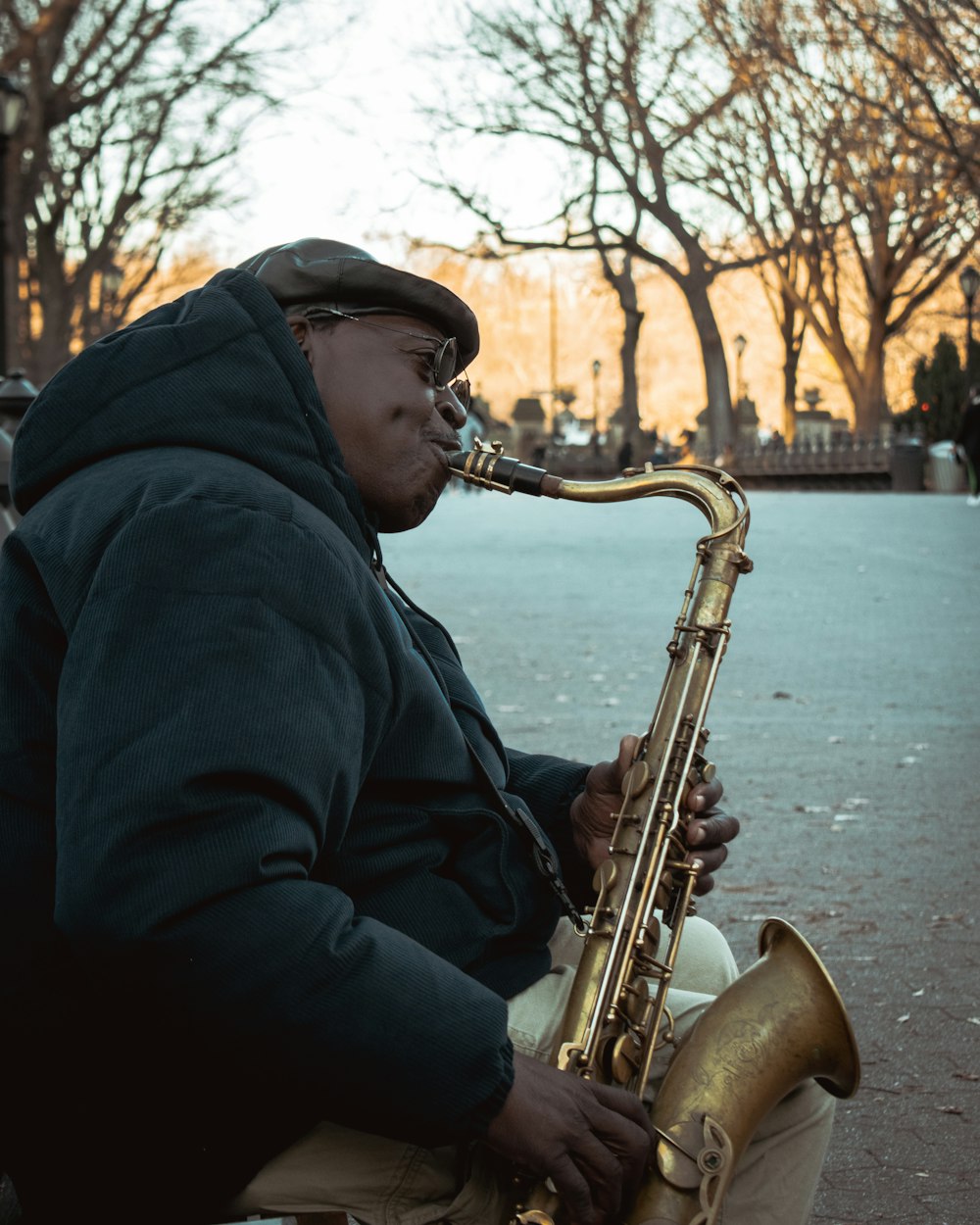 a man sitting on a bench playing a saxophone
