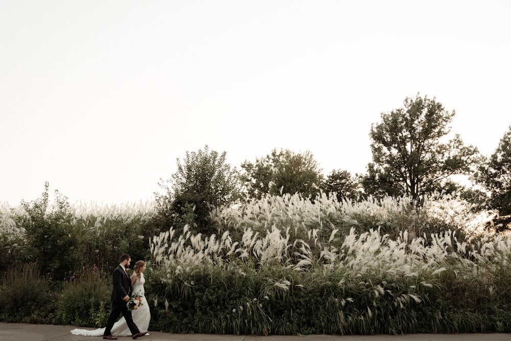 a bride and groom walking down the street