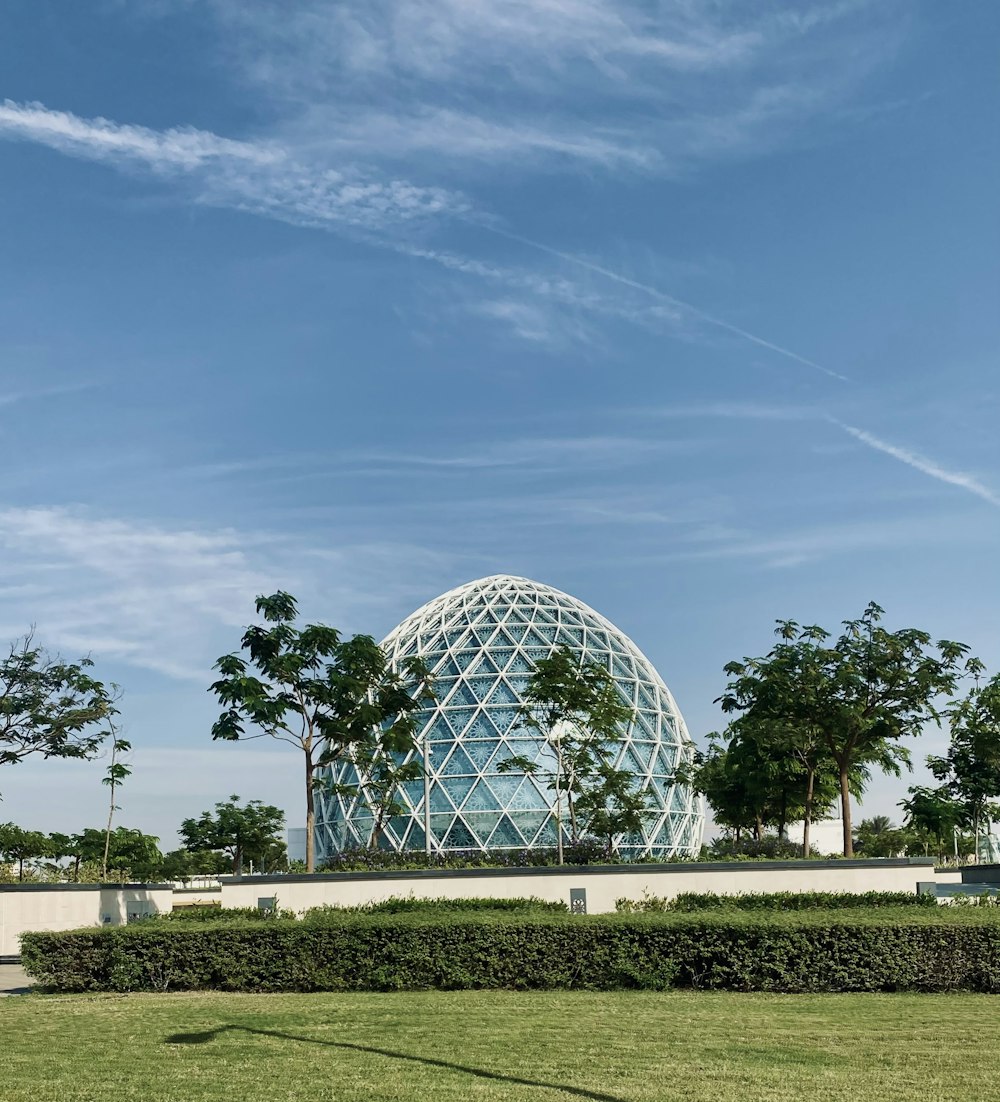 a large glass dome sitting on top of a lush green field