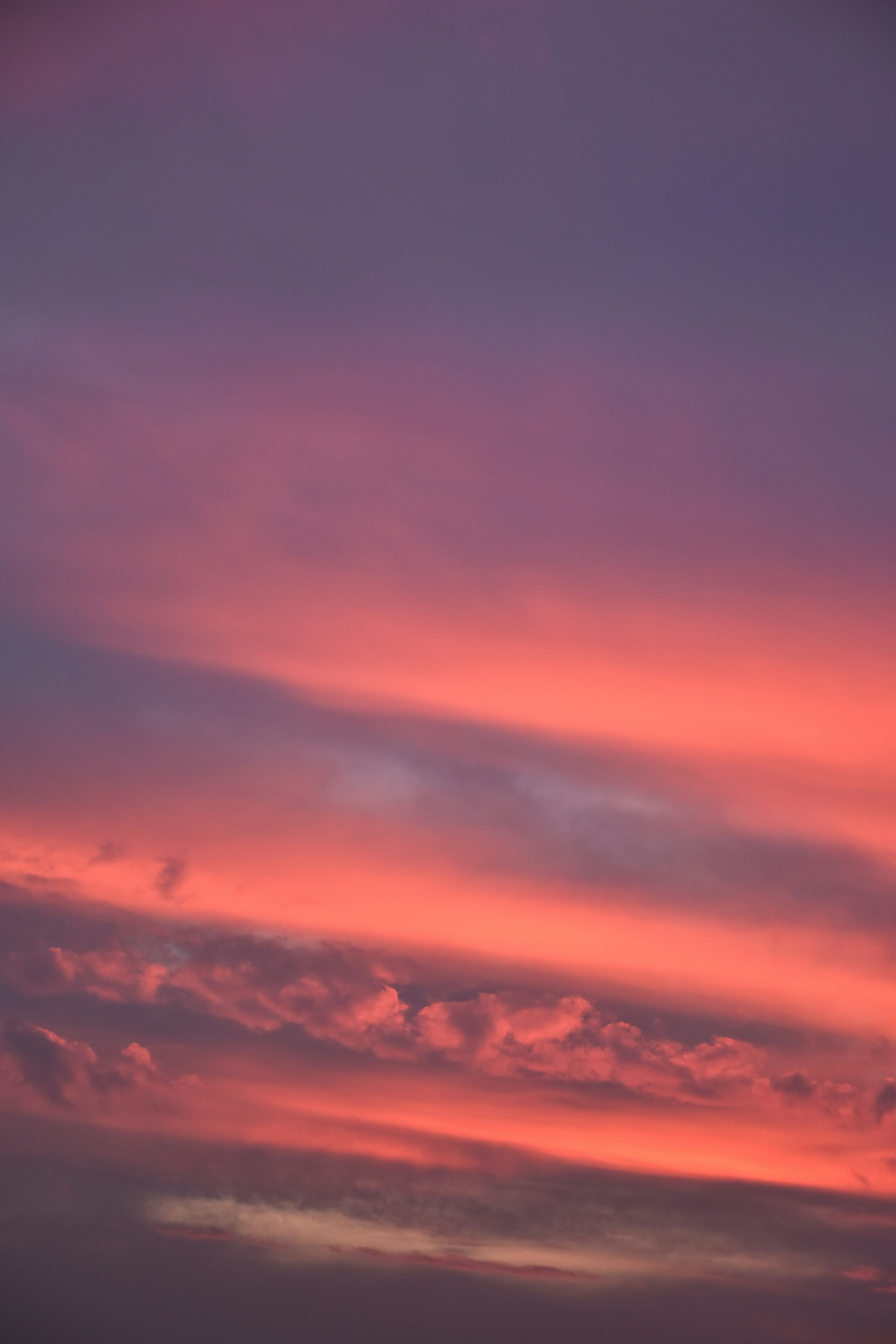 a plane flying in the sky at sunset