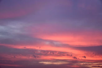 a plane flying in the sky at sunset