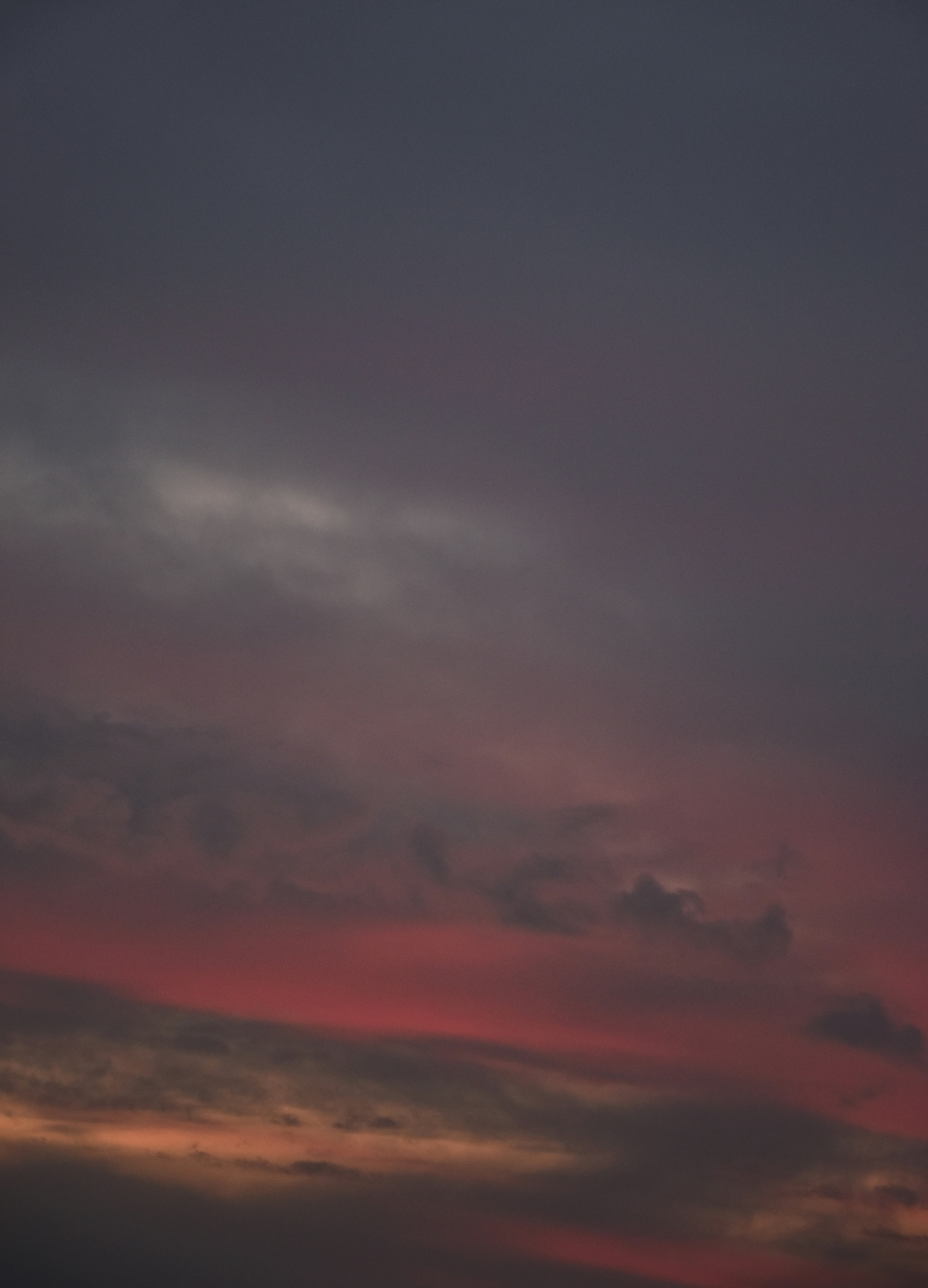 a plane flying in the sky at sunset