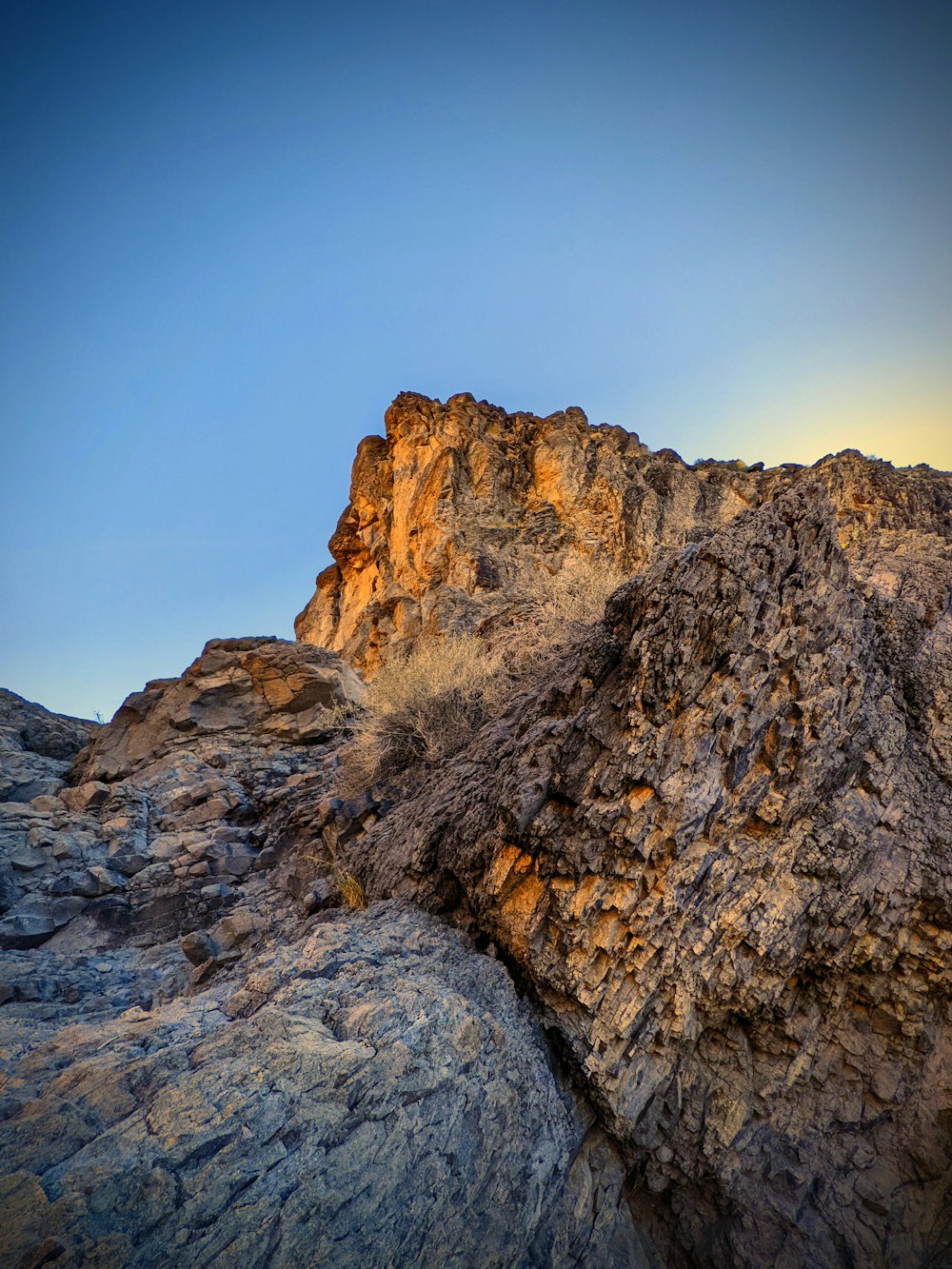 a rock formation with a blue sky in the background