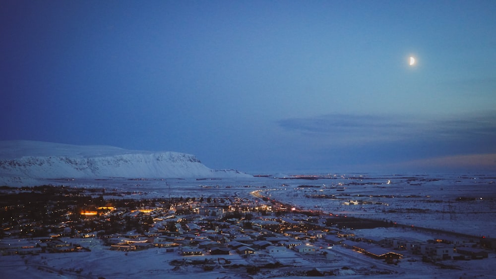 a snowy landscape with a full moon in the sky