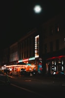 a city street at night with a building lit up