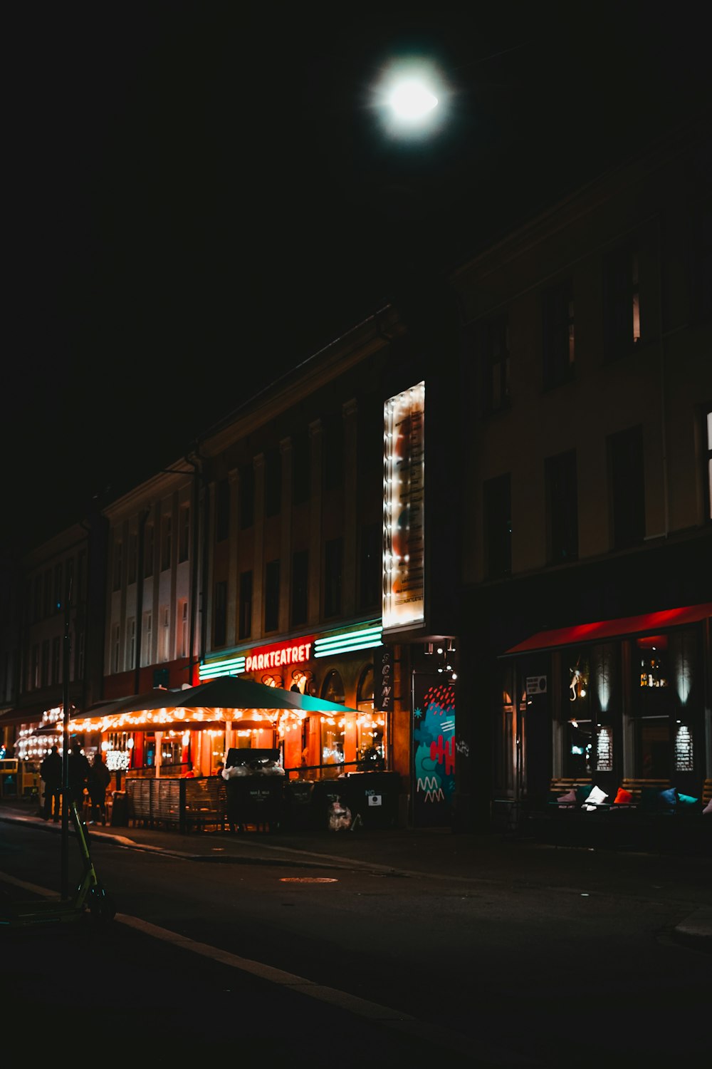 a city street at night with a building lit up