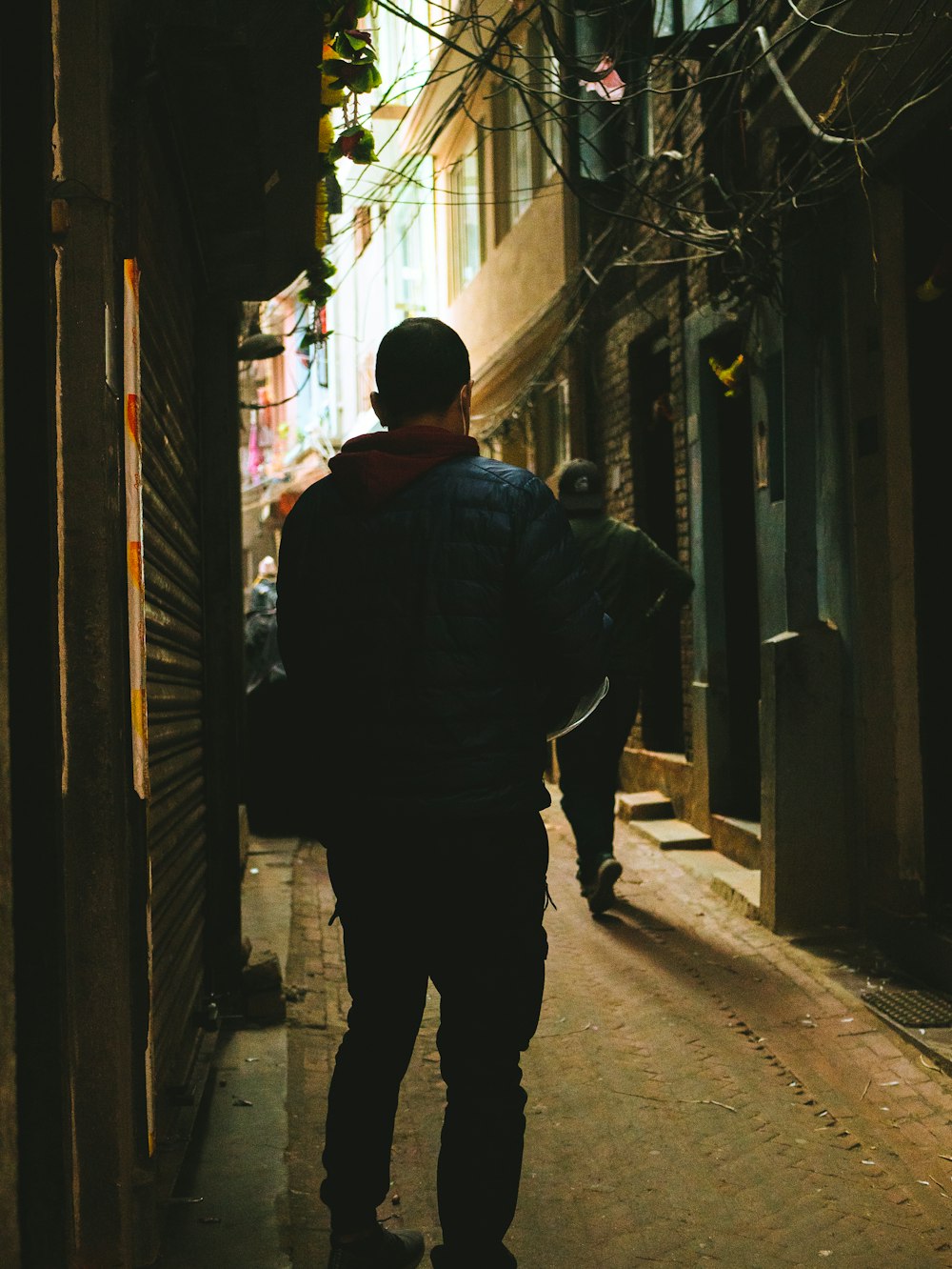 a man walking down a narrow alley way