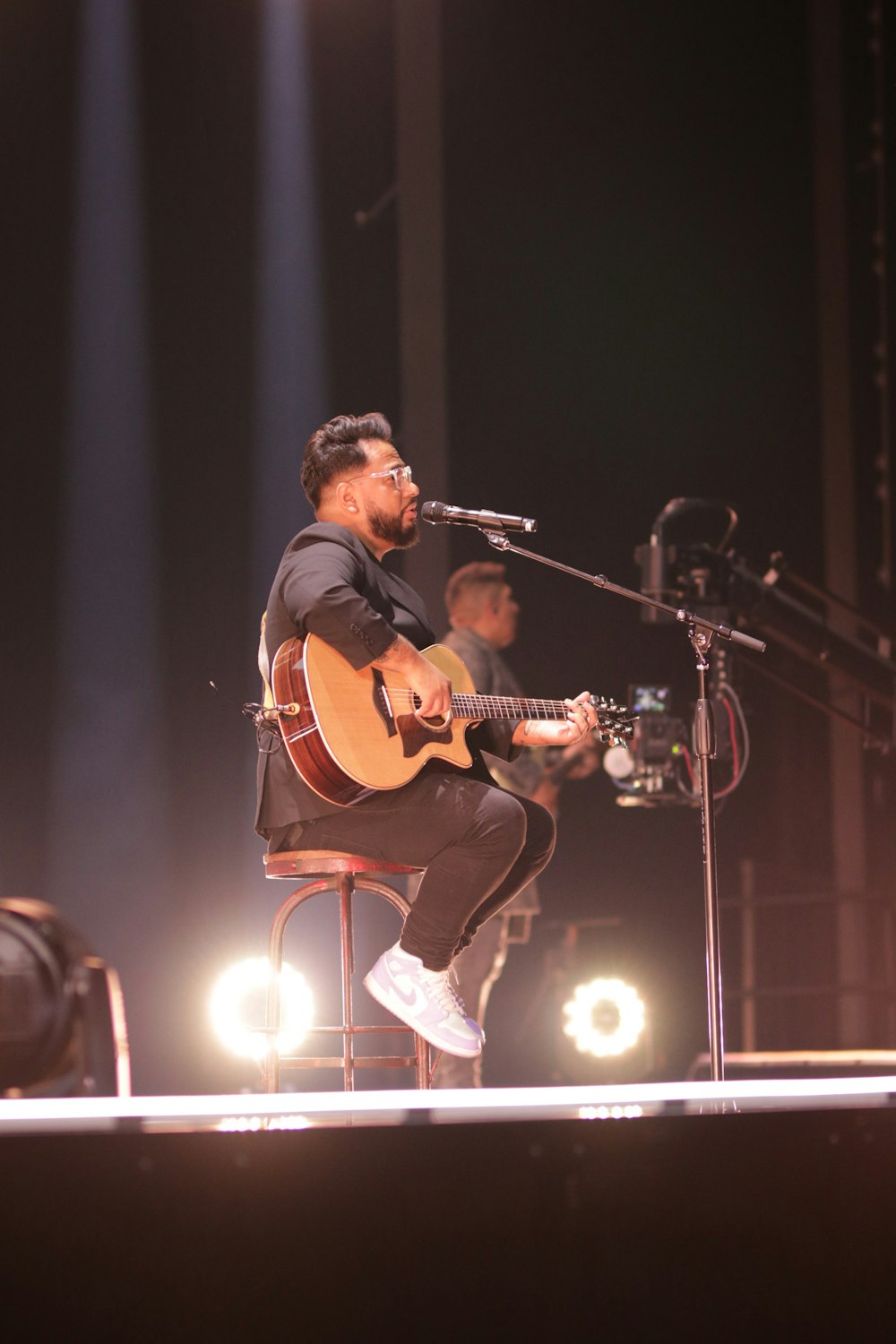 a man with a guitar on a stage