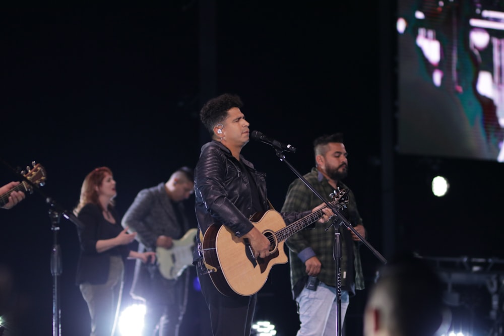 a group of people on stage with guitars