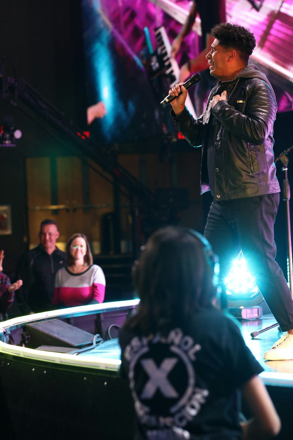 a man standing on a stage holding a microphone